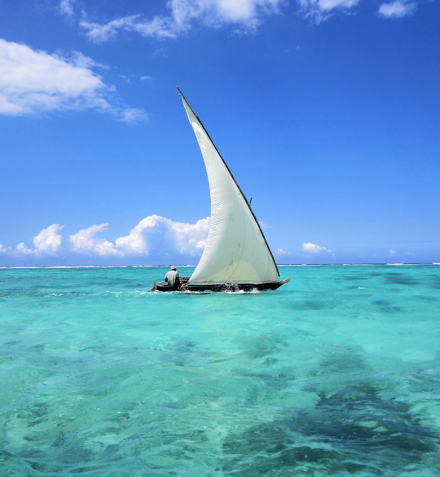 dhow sailing on the turquoise waters off the coast of Zanzibar